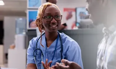 South Carolina medical assistant smiling and discussing treatment with patient in clinic