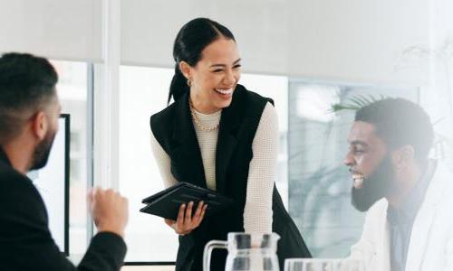 Business analyst smiling with team during weekly meeting 